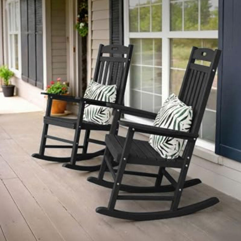 Two black rocking chairs with zebra print cushions on a porch.
