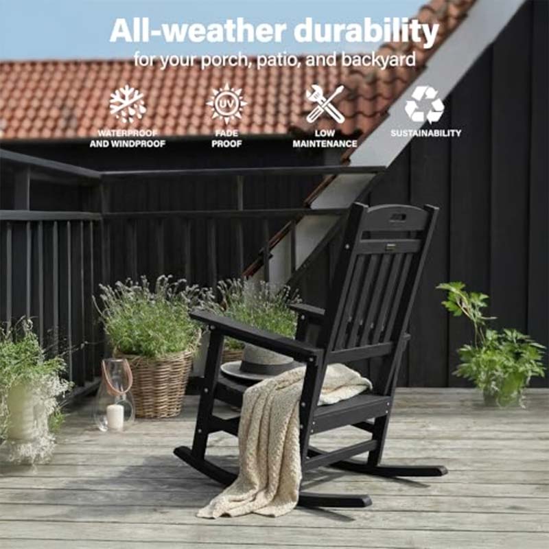 Black rocking chair on a wooden deck with plants and a house in the background, emphasizing durability for outdoor use.