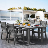 Outdoor dining set on a wooden deck with a modern house in the background