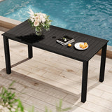 Black outdoor table with a vase of flowers, books, and a plate of oranges by a pool.
